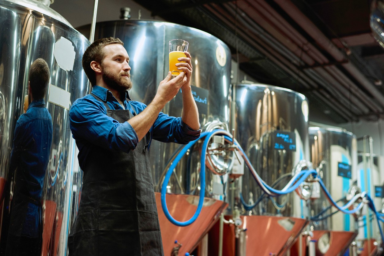 brewmaster-inspecting-beer-near-vats