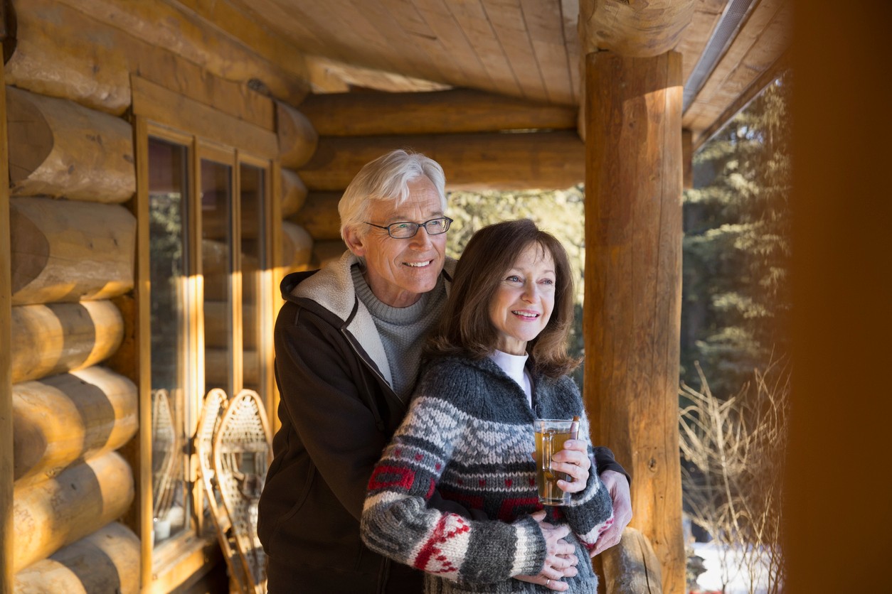 older-couple-standing-on-cabin-porch