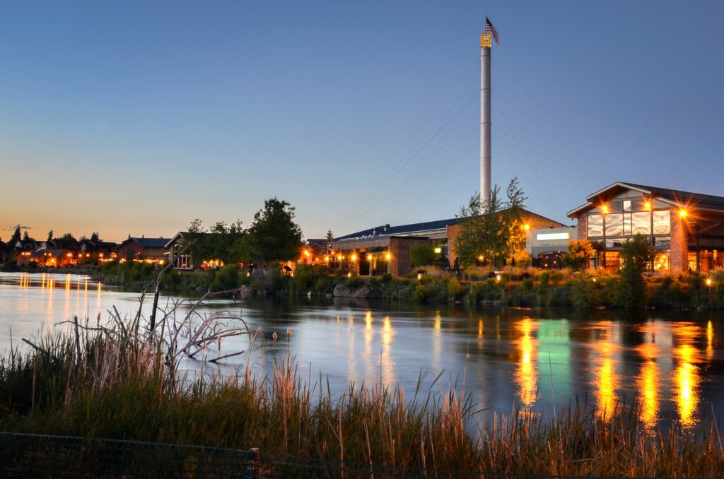 Old Mill District in Bend, Oregon at night with the Deschutes River in the foreground. 